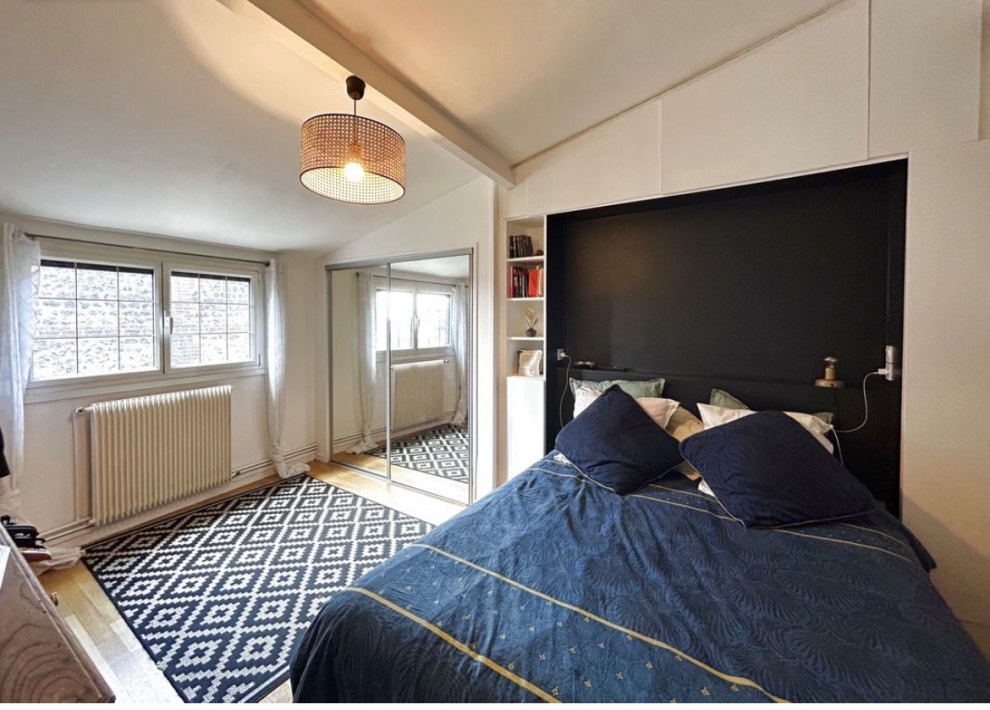 Bild på ett litet vintage sovrum, med vita väggar, ljust trägolv och brunt golv