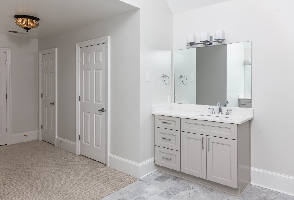 Cette image montre une grande salle de bain principale design avec un placard à porte shaker, des portes de placard grises, une baignoire en alcôve, une douche d'angle, WC séparés, du carrelage en marbre, un mur gris, un sol en marbre, un lavabo encastré, un plan de toilette en quartz modifié, une cabine de douche à porte battante, un plan de toilette blanc, une niche, meuble-lavabo encastré et un plafond voûté.