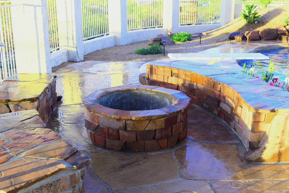 Hot tub - large backyard kidney-shaped hot tub idea in Phoenix