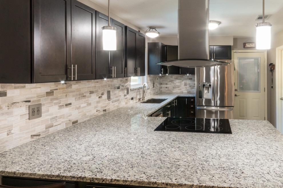 Inspiration for a mid-sized u-shaped ceramic tile and beige floor eat-in kitchen remodel with an undermount sink, shaker cabinets, black cabinets, granite countertops, glass tile backsplash, stainless steel appliances, an island and white countertops