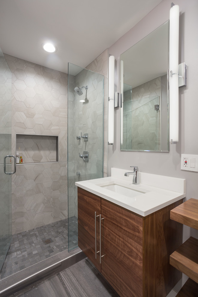 Mid-sized contemporary master bathroom in Chicago with flat-panel cabinets, medium wood cabinets, an alcove shower, a one-piece toilet, multi-coloured tile, mosaic tile, grey walls, marble floors, an undermount sink and limestone benchtops.