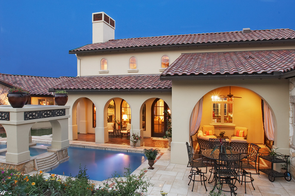 This is an example of a mediterranean two-storey exterior in Austin with a tile roof.