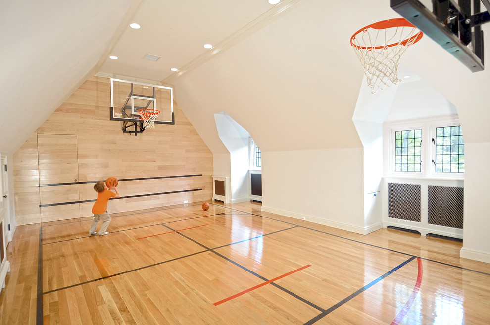 Large traditional indoor sport court in Other with white walls and light hardwood floors.