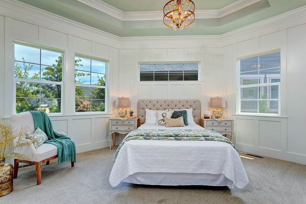 This is an example of a large beach style master bedroom in Boise with white walls, carpet and no fireplace.