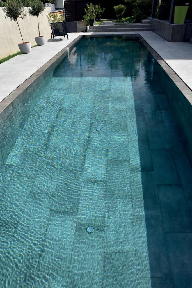 Modern rectangular pool with with a pool and tile.