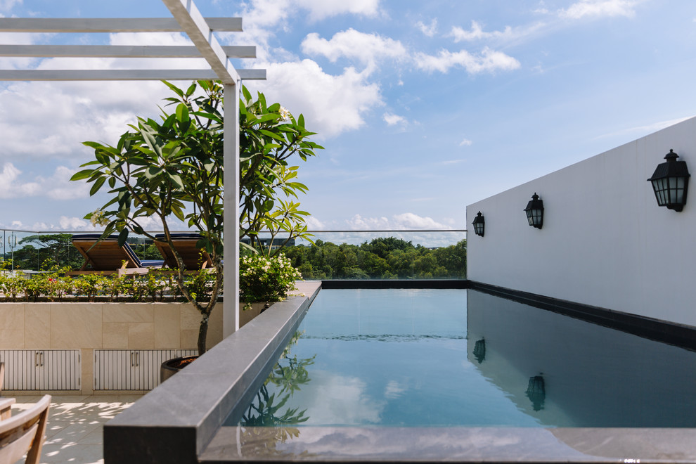 Photo of an asian rooftop rectangular aboveground pool in Singapore with tile.