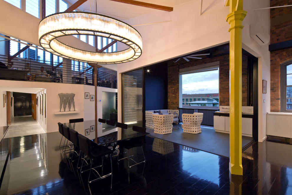 Photo of a large industrial open plan dining in Brisbane with white walls, dark hardwood floors and black floor.