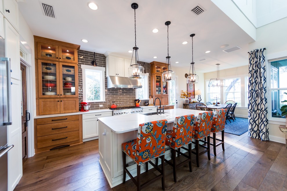 This is an example of a large country galley eat-in kitchen in Jacksonville with an undermount sink, shaker cabinets, medium wood cabinets, quartz benchtops, brown splashback, porcelain splashback, stainless steel appliances, medium hardwood floors, with island and brown floor.