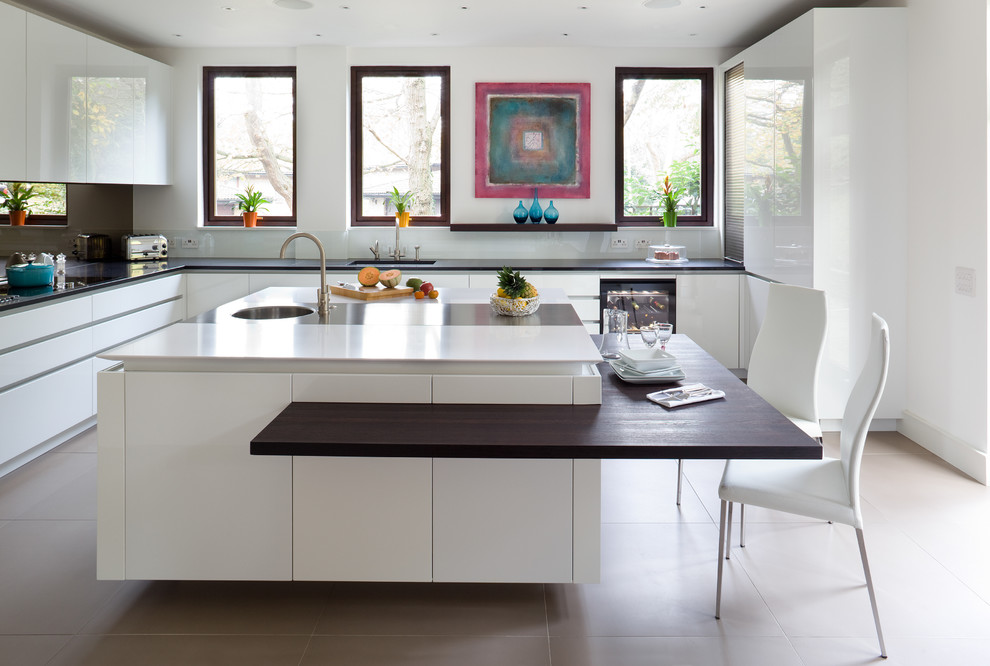 Contemporary l-shaped kitchen in London with flat-panel cabinets, white cabinets and with island.
