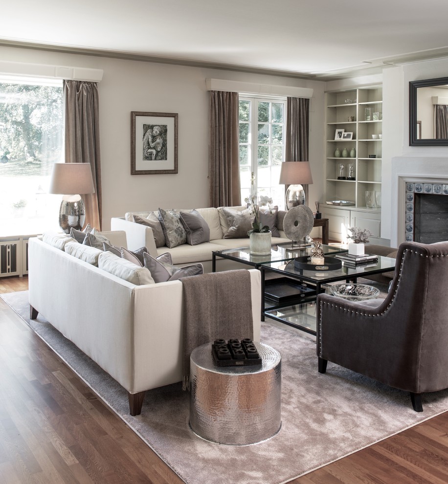 Transitional living room with white walls, medium hardwood floors and a standard fireplace.