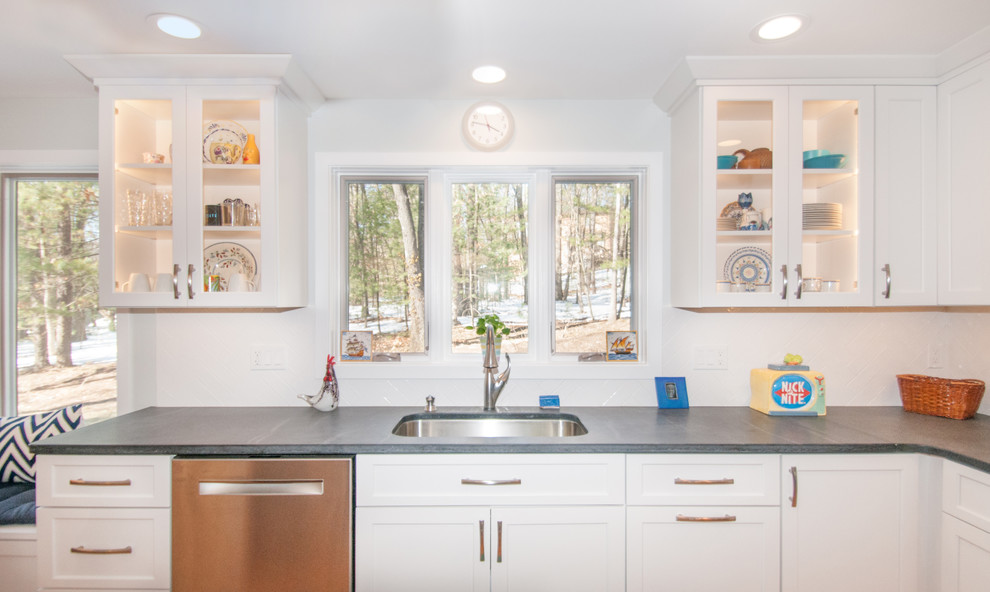 Eat-in kitchen - transitional l-shaped medium tone wood floor eat-in kitchen idea in Boston with a double-bowl sink, glass-front cabinets, white cabinets, white backsplash, stainless steel appliances, an island, soapstone countertops and ceramic backsplash