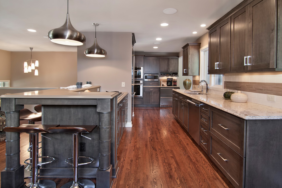 Example of a transitional kitchen design in Minneapolis with raised-panel cabinets, stainless steel appliances and an island