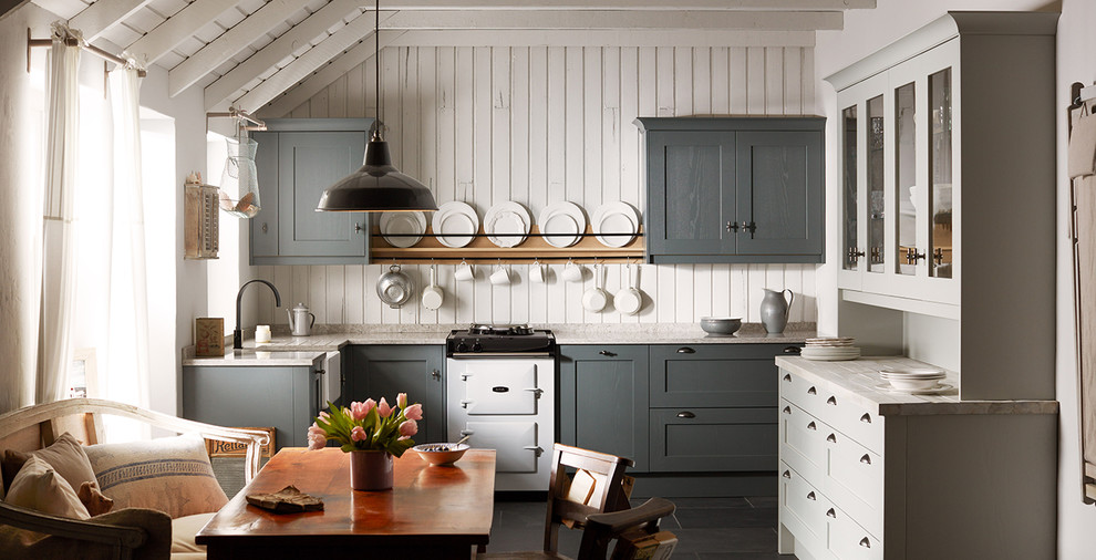 This is an example of a mid-sized country l-shaped eat-in kitchen in Dublin with a farmhouse sink, shaker cabinets, distressed cabinets, solid surface benchtops, white appliances, ceramic floors and no island.