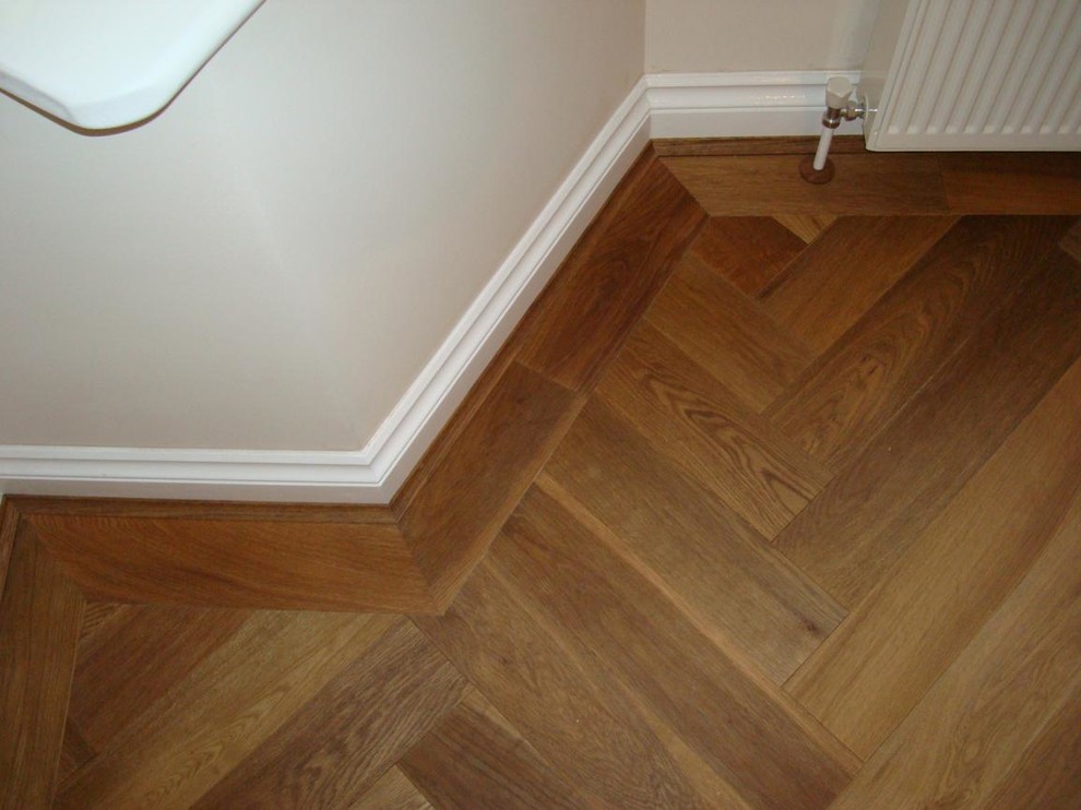 This is an example of a mid-sized traditional hallway in London with white walls and medium hardwood floors.