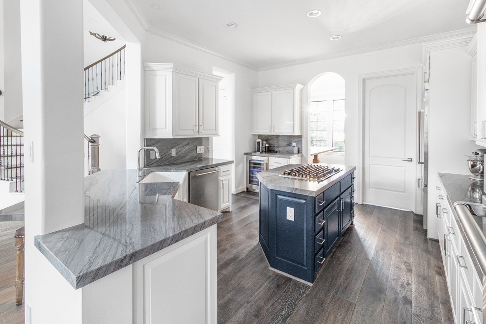 Inspiration for a mid-sized transitional galley medium tone wood floor and gray floor eat-in kitchen remodel in Houston with a farmhouse sink, raised-panel cabinets, blue cabinets, quartzite countertops, gray backsplash, stone slab backsplash, stainless steel appliances, an island and gray countertops