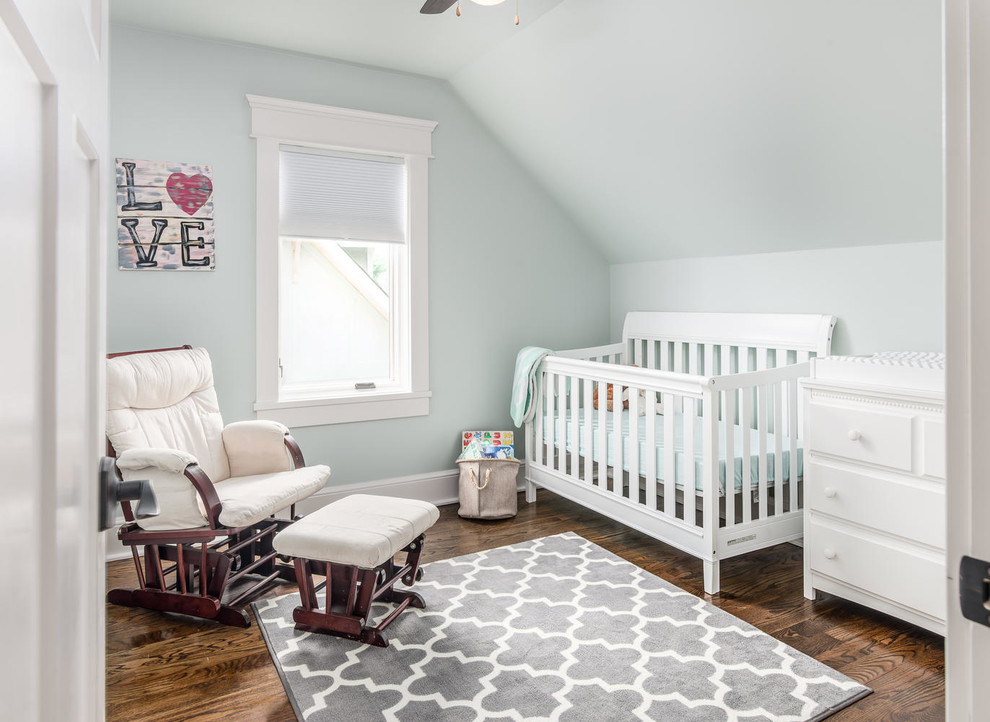 Small arts and crafts gender-neutral nursery in Nashville with green walls, medium hardwood floors and brown floor.