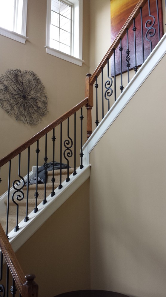 Large mediterranean wood curved staircase in Charlotte with painted wood risers.