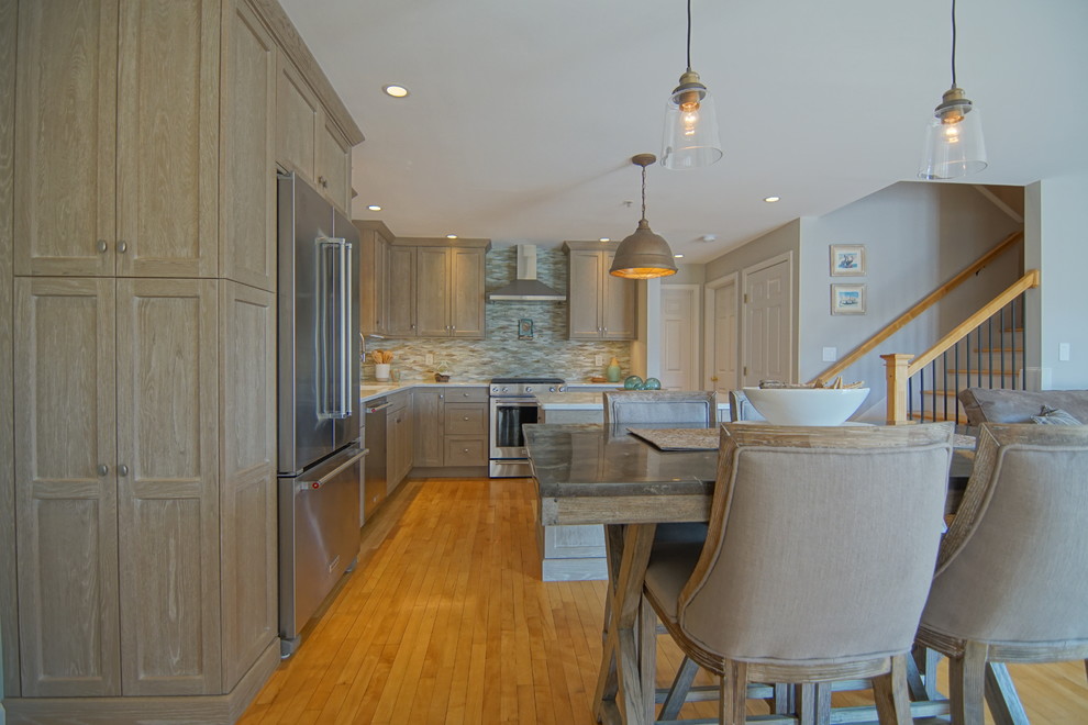Example of a mid-sized transitional l-shaped medium tone wood floor and beige floor eat-in kitchen design with an undermount sink, beaded inset cabinets, distressed cabinets, marble countertops, gray backsplash, ceramic backsplash, stainless steel appliances, an island and white countertops