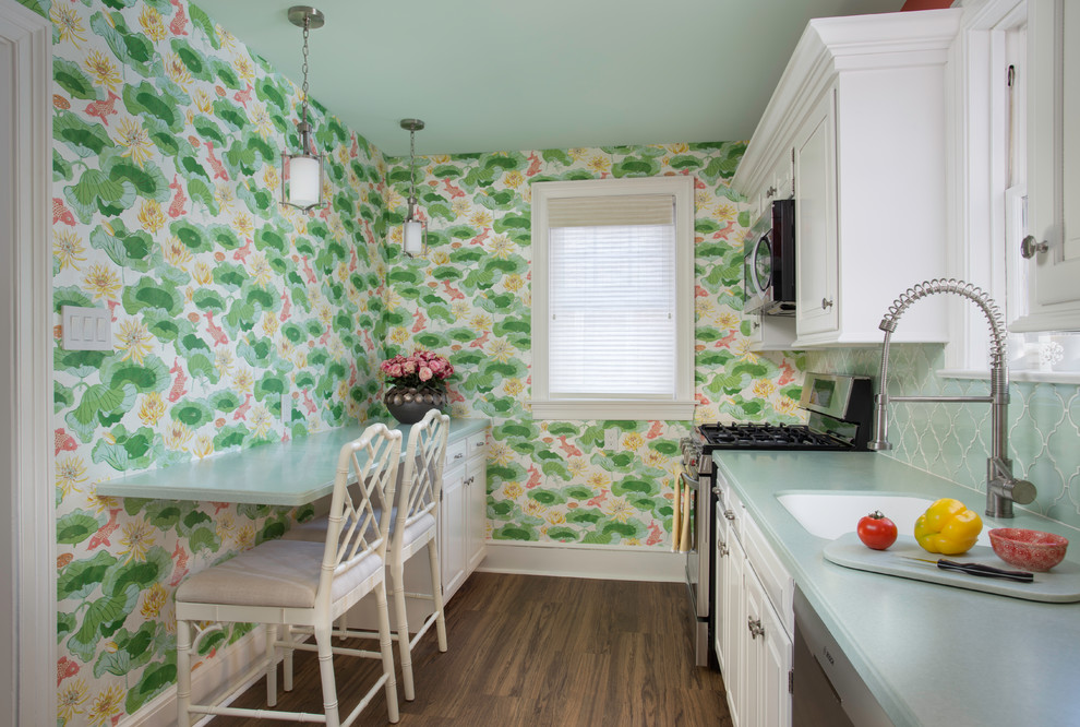 Small traditional galley kitchen in Other with an integrated sink, raised-panel cabinets, white cabinets, solid surface benchtops, green splashback, glass tile splashback, stainless steel appliances, vinyl floors, brown floor and green benchtop.