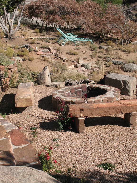 This is an example of a mid-sized traditional backyard full sun formal garden for fall in Albuquerque with with rock feature and natural stone pavers.