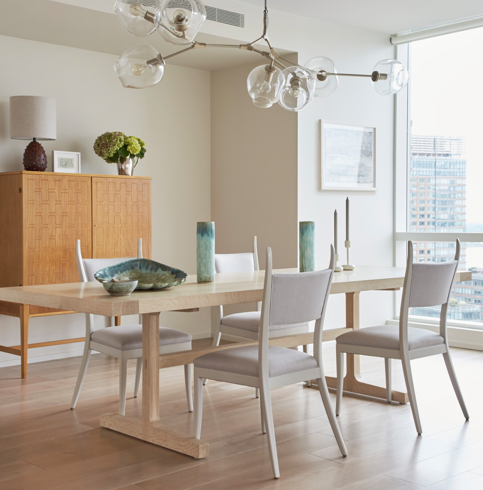 Design ideas for a contemporary dining room in New York with light hardwood floors, no fireplace and white walls.