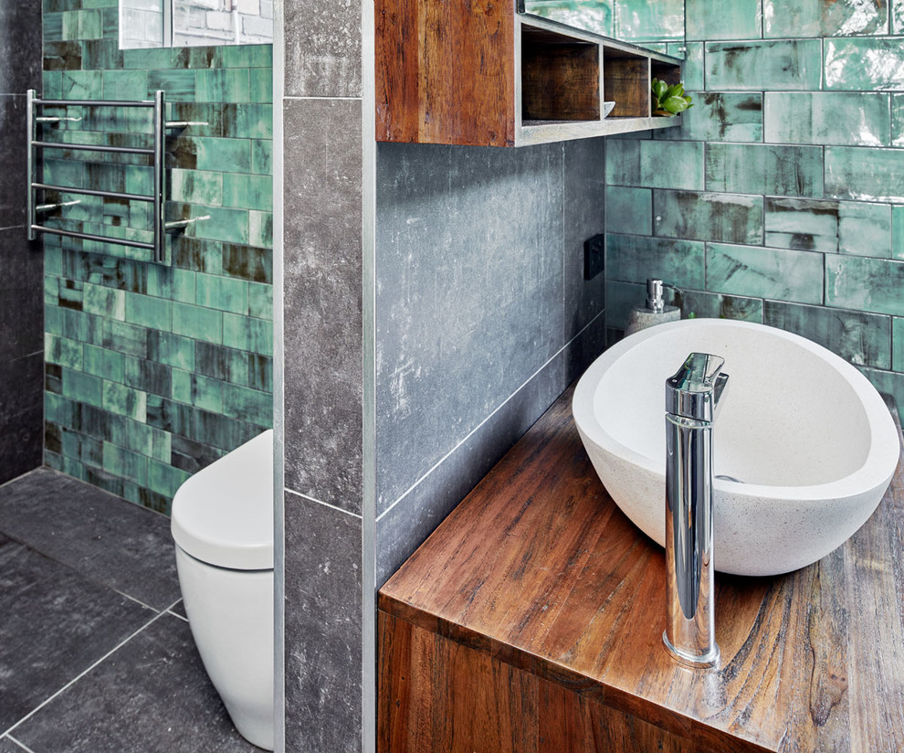 Design ideas for a large contemporary master wet room bathroom in Sydney with furniture-like cabinets, medium wood cabinets, a freestanding tub, gray tile, porcelain tile, green walls, porcelain floors, a vessel sink, wood benchtops, grey floor and an open shower.