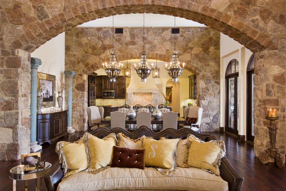 Photo of a large mediterranean open concept living room in Austin with brown walls, dark hardwood floors and brown floor.