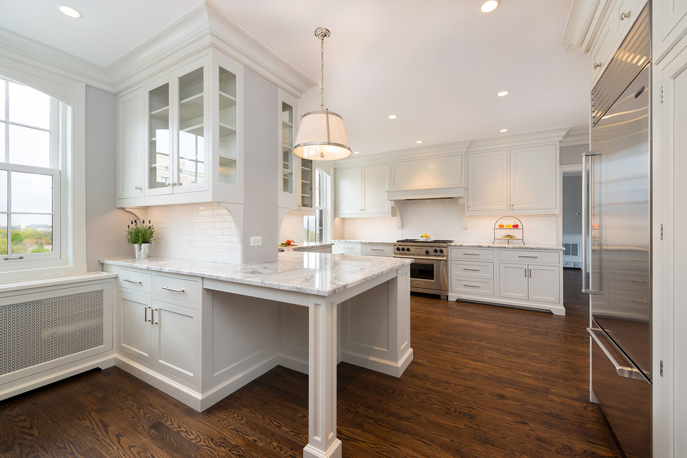 Mid-sized transitional u-shaped dark wood floor and brown floor eat-in kitchen photo in Chicago with beaded inset cabinets, white cabinets, marble countertops, white backsplash, subway tile backsplash, stainless steel appliances and a peninsula