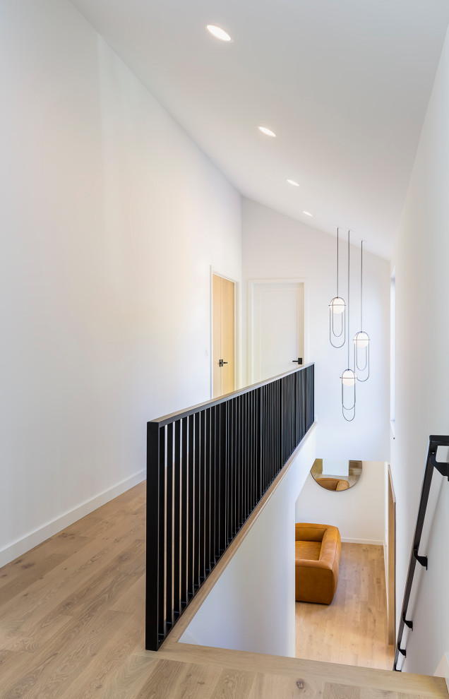 This is an example of a medium sized scandinavian wood straight metal railing staircase in Minneapolis with wood risers.