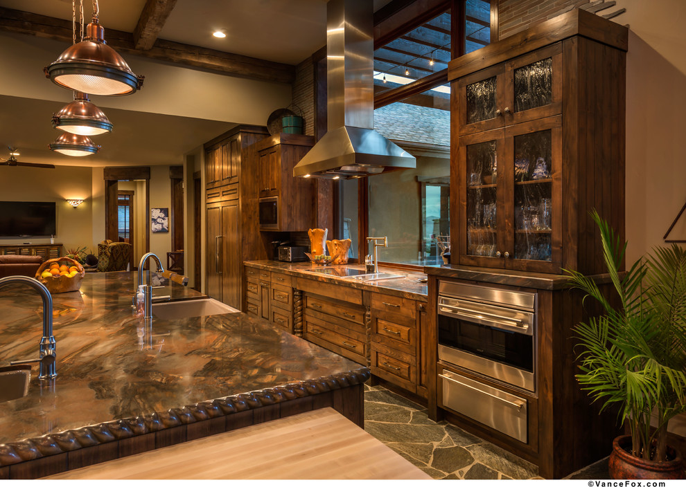 Eat-in kitchen - large rustic u-shaped eat-in kitchen idea with a farmhouse sink, distressed cabinets, marble countertops, stone tile backsplash, stainless steel appliances and an island