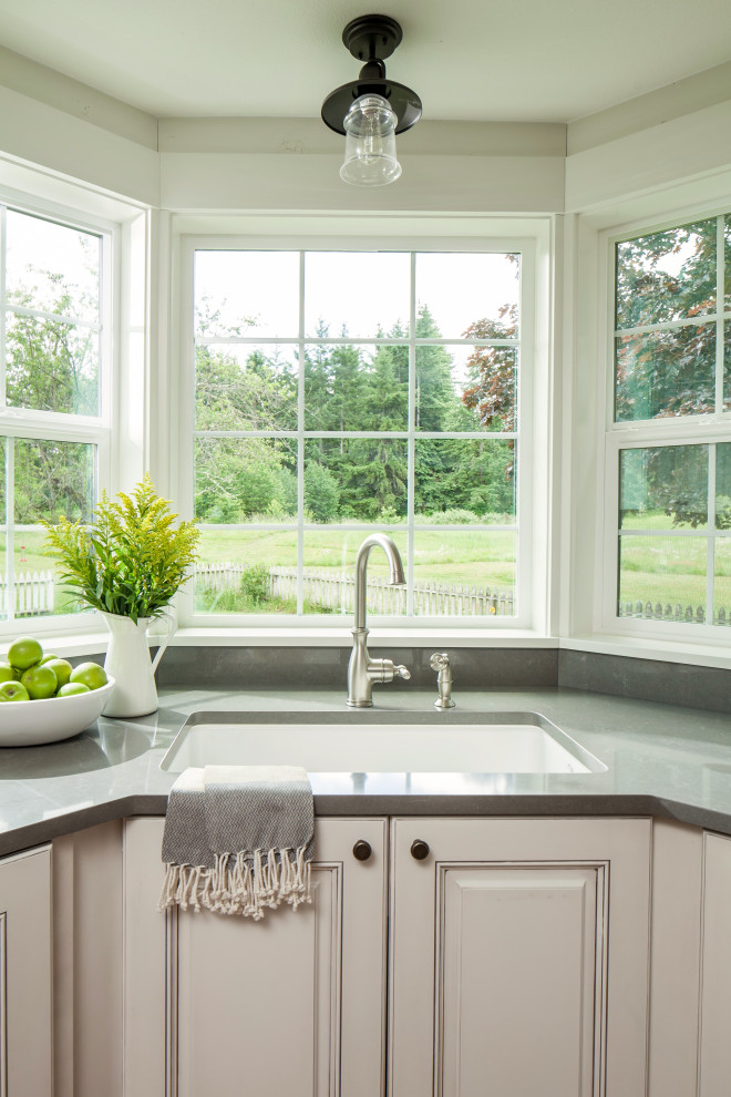 Inspiration for a medium sized rural u-shaped open plan kitchen in Seattle with a submerged sink, raised-panel cabinets, white cabinets, engineered stone countertops, white splashback, tonge and groove splashback, stainless steel appliances, medium hardwood flooring, an island, brown floors and grey worktops.