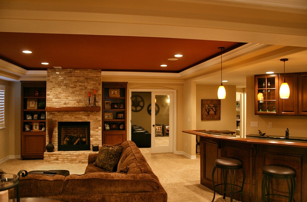 Design ideas for a large transitional look-out basement in Denver with beige walls, carpet, a standard fireplace, a stone fireplace surround and beige floor.