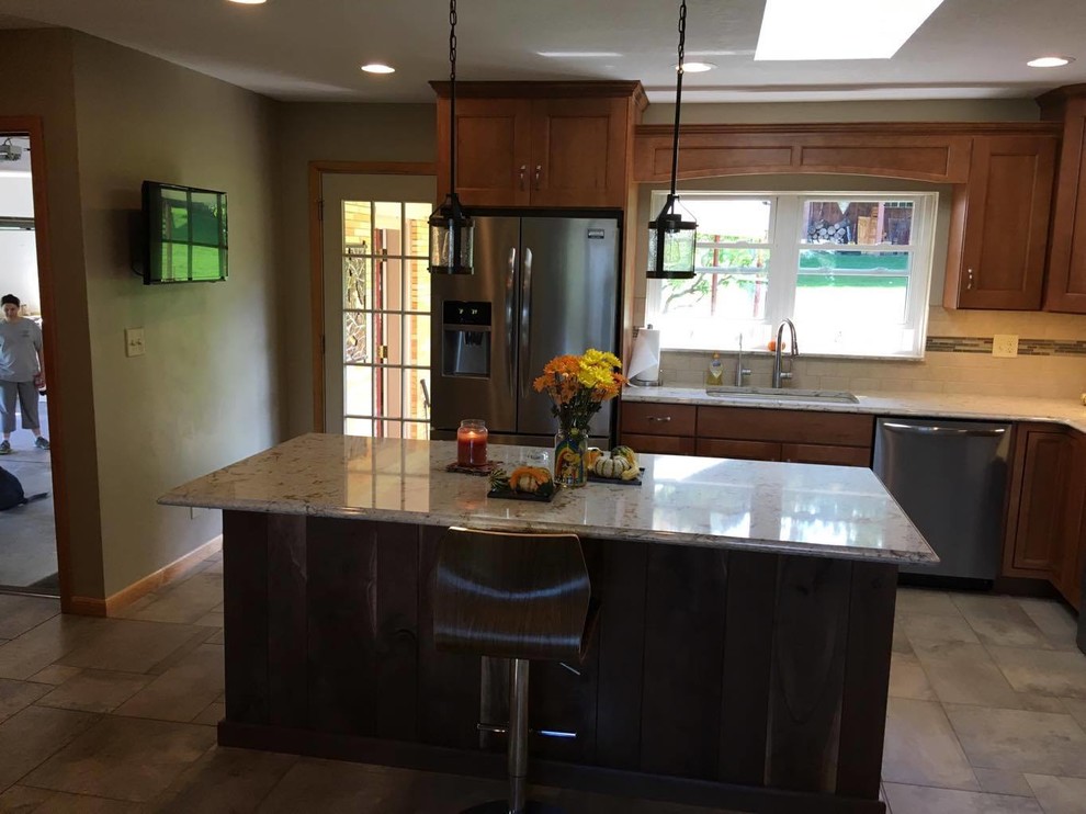 Example of a mid-sized transitional l-shaped porcelain tile and multicolored floor eat-in kitchen design with an undermount sink, recessed-panel cabinets, medium tone wood cabinets, quartz countertops, beige backsplash, porcelain backsplash, stainless steel appliances and an island