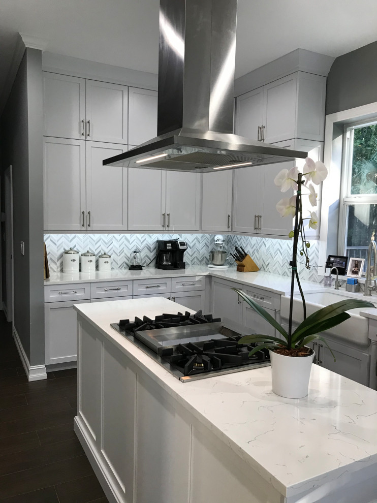 Eat-in kitchen - large transitional u-shaped porcelain tile and brown floor eat-in kitchen idea in Miami with a farmhouse sink, recessed-panel cabinets, white cabinets, quartz countertops, gray backsplash, marble backsplash, stainless steel appliances, an island and white countertops