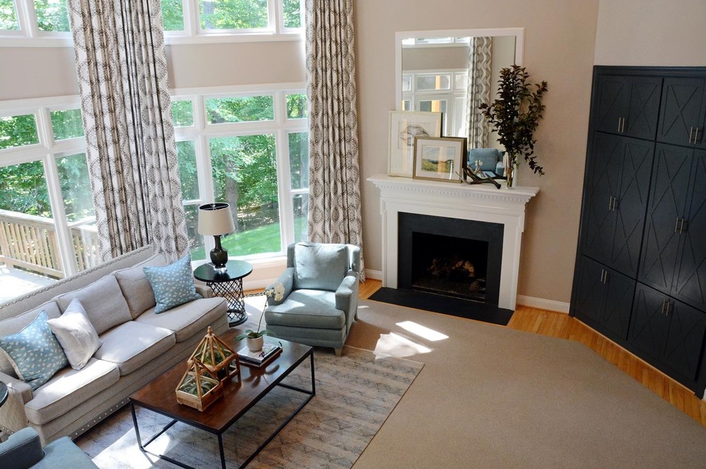 Inspiration for a transitional open concept family room in DC Metro with beige walls, light hardwood floors, a standard fireplace and no tv.