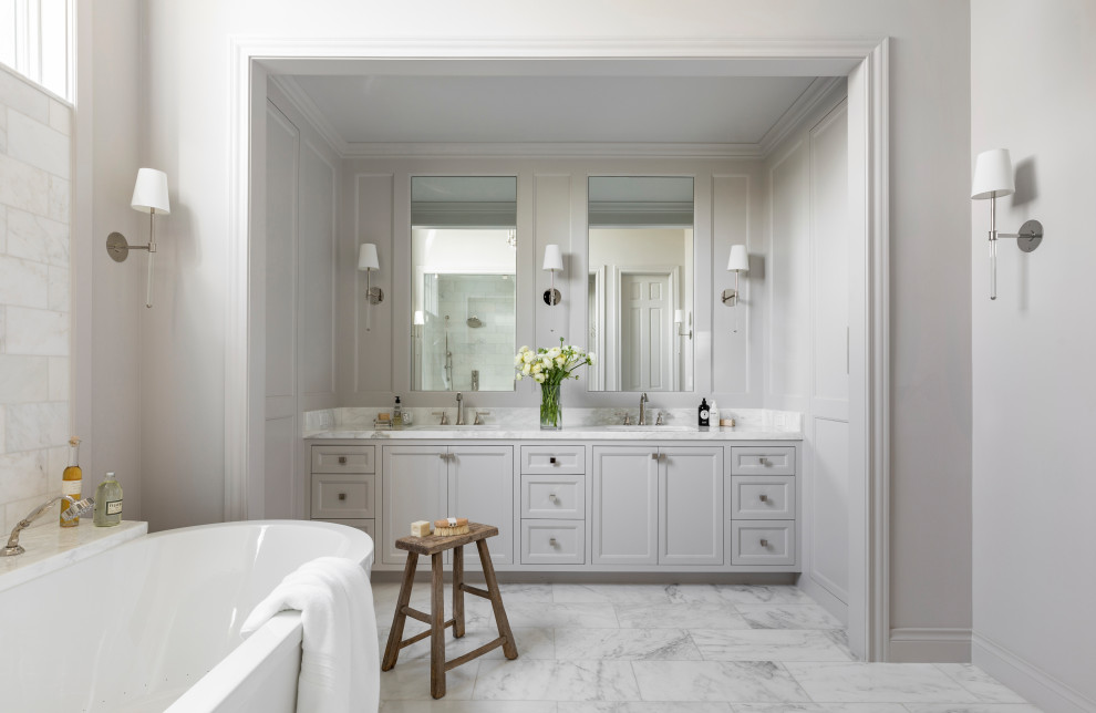 Idee per una stanza da bagno classica con ante bianche, vasca freestanding, pavimento in marmo, pavimento bianco, due lavabi e mobile bagno incassato
