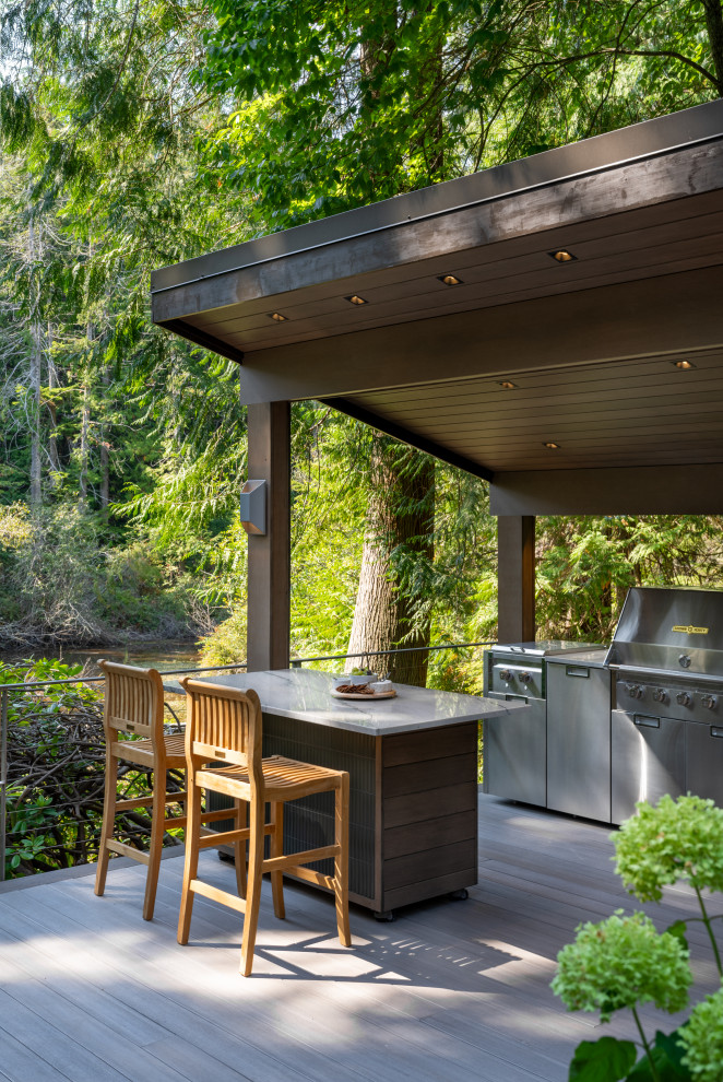 Outdoor kitchen deck - large contemporary backyard ground level metal railing outdoor kitchen deck idea in Seattle with a pergola