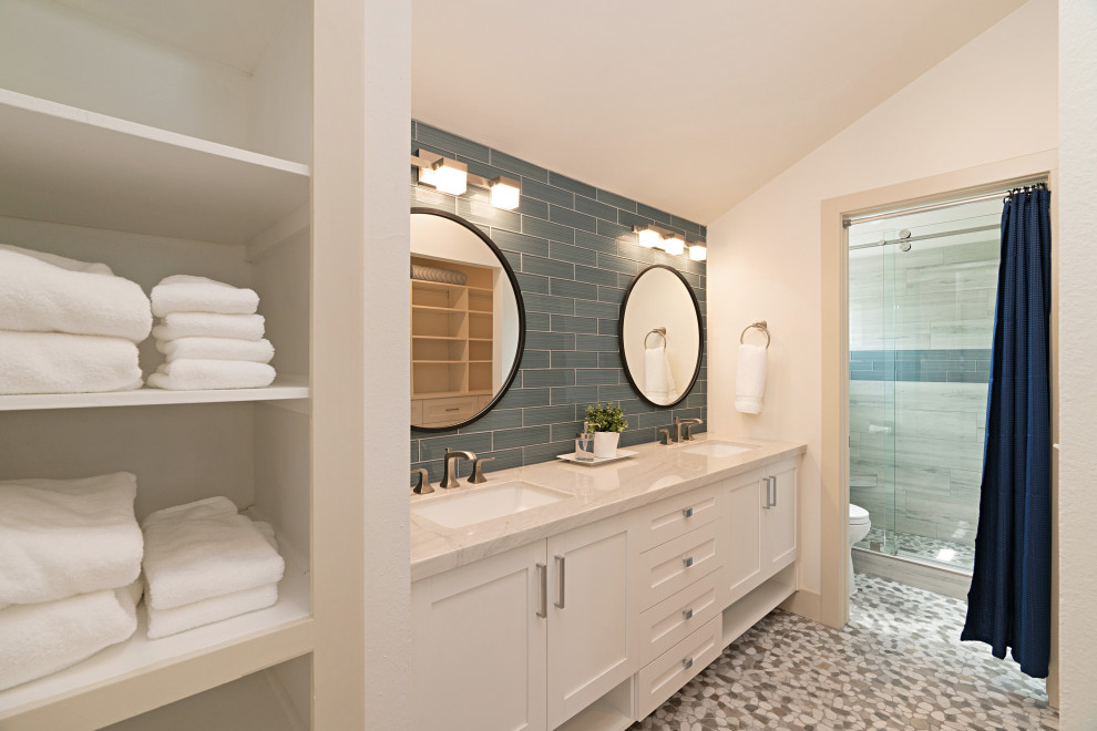 Exemple d'une salle de bain principale bord de mer de taille moyenne avec un placard à porte shaker, des portes de placard blanches, WC séparés, un carrelage bleu, un carrelage en pâte de verre, un mur blanc, un sol en carrelage de terre cuite, un lavabo encastré, un plan de toilette en quartz, une cabine de douche à porte coulissante, un plan de toilette gris, meuble double vasque, meuble-lavabo encastré et un plafond voûté.