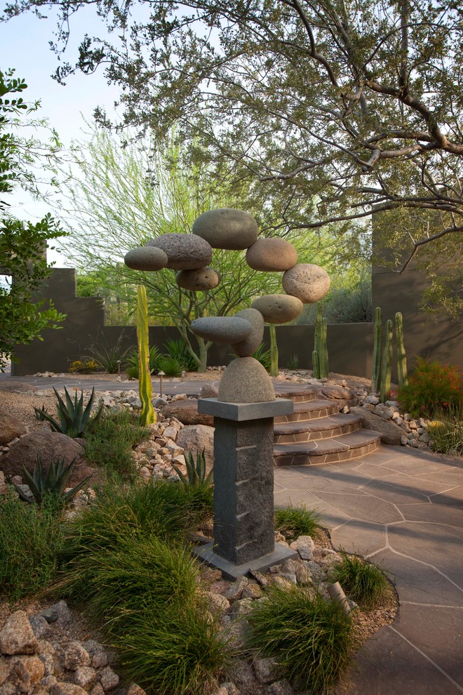 This is an example of a contemporary backyard xeriscape in Phoenix with natural stone pavers.