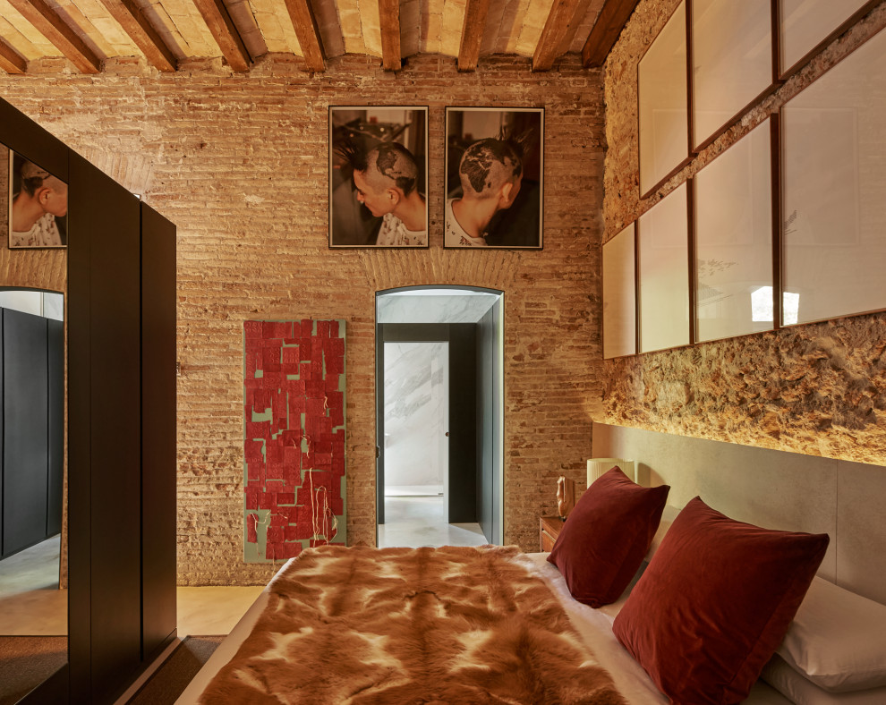 Inspiration pour une chambre mansardée ou avec mezzanine minimaliste avec sol en béton ciré, poutres apparentes et un mur en parement de brique.