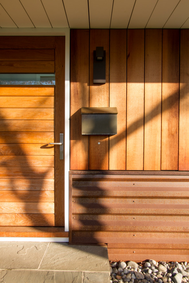 Ejemplo de puerta principal retro pequeña con paredes blancas, suelo de pizarra, puerta pivotante, puerta de madera clara, suelo gris y bandeja