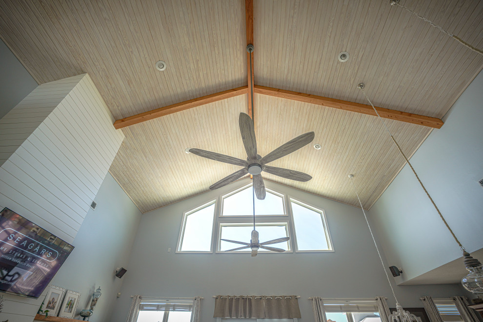 Photo of a large nautical open plan games room in Miami with blue walls, exposed beams and tongue and groove walls.