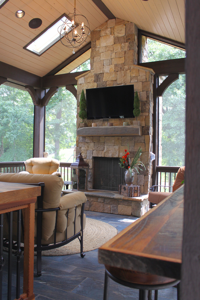 Inspiration for a mid-sized country backyard patio in Charlotte with a fire feature, tile and a roof extension.