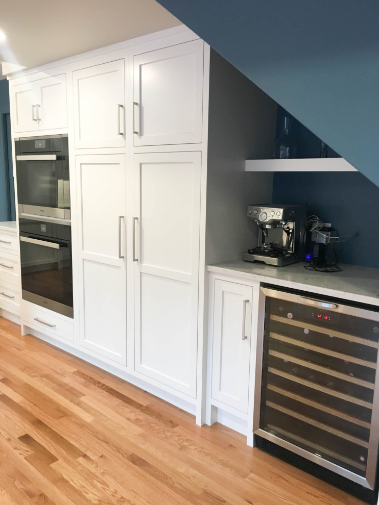 Inspiration for a large transitional u-shaped light wood floor and beige floor eat-in kitchen remodel with a double-bowl sink, shaker cabinets, white cabinets, quartzite countertops, white backsplash, subway tile backsplash, stainless steel appliances, an island and white countertops