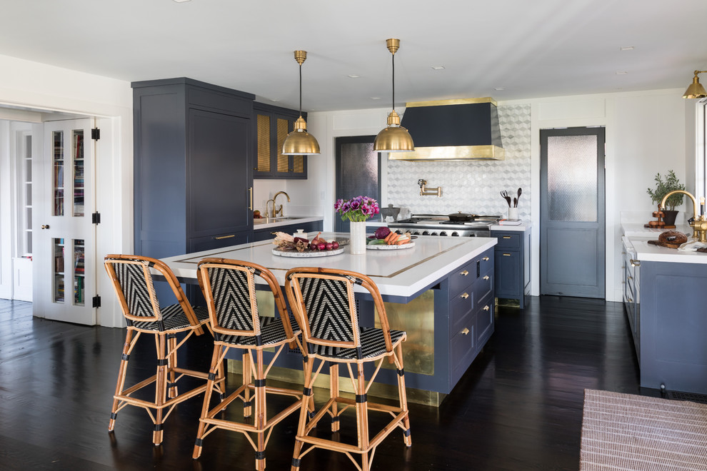 Transitional kitchen in New York with a farmhouse sink, blue cabinets, stainless steel appliances, with island, shaker cabinets, metallic splashback, metal splashback and dark hardwood floors.
