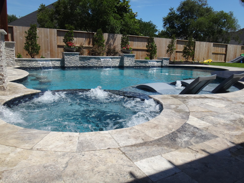 Inspiration for a large transitional backyard custom-shaped lap pool in Houston with a hot tub and natural stone pavers.