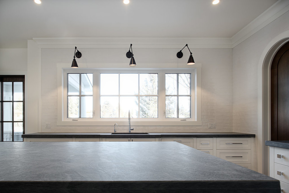 Example of a large transitional u-shaped eat-in kitchen design in Calgary with shaker cabinets, paneled appliances and an island