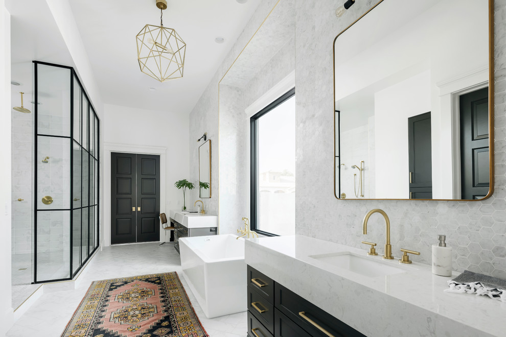 Example of a mid-sized transitional master gray tile and marble tile ceramic tile and gray floor freestanding bathtub design in Phoenix with shaker cabinets, black cabinets, a one-piece toilet, white walls, an undermount sink and quartz countertops