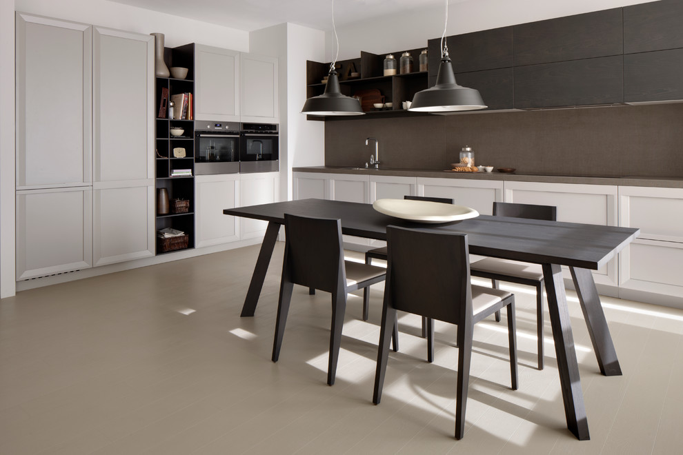 Large contemporary l-shaped eat-in kitchen in Madrid with flat-panel cabinets, grey splashback, stainless steel appliances, painted wood floors, no island and white cabinets.