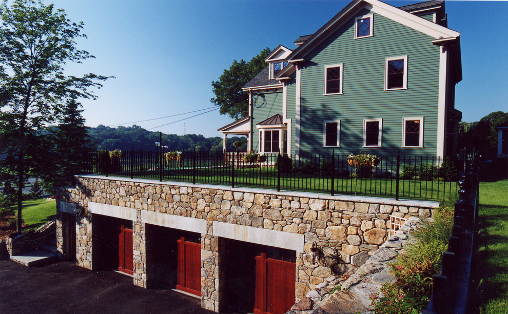 Photo of a large traditional attached three-car garage in Boston.